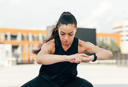 Young fit woman exercising outdoors  Sportswoman in fitness attire doing warm up exercises