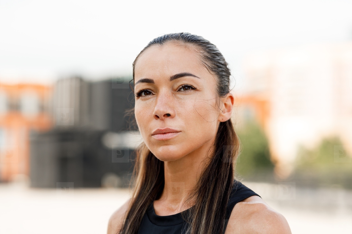 Close up portrait of a young sportswoman with long hair looking at camera
