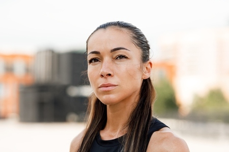 Close up portrait of a young sportswoman with long hair looking at camera
