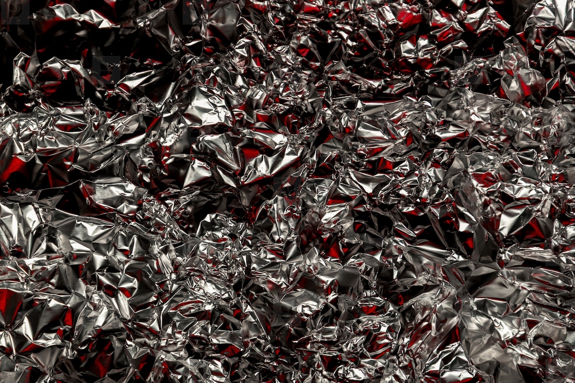 Shiny crumpled foil with silver and red reflections creating a metallic abstract design  Futuristic texture with chrome surface and cyberpunk background style