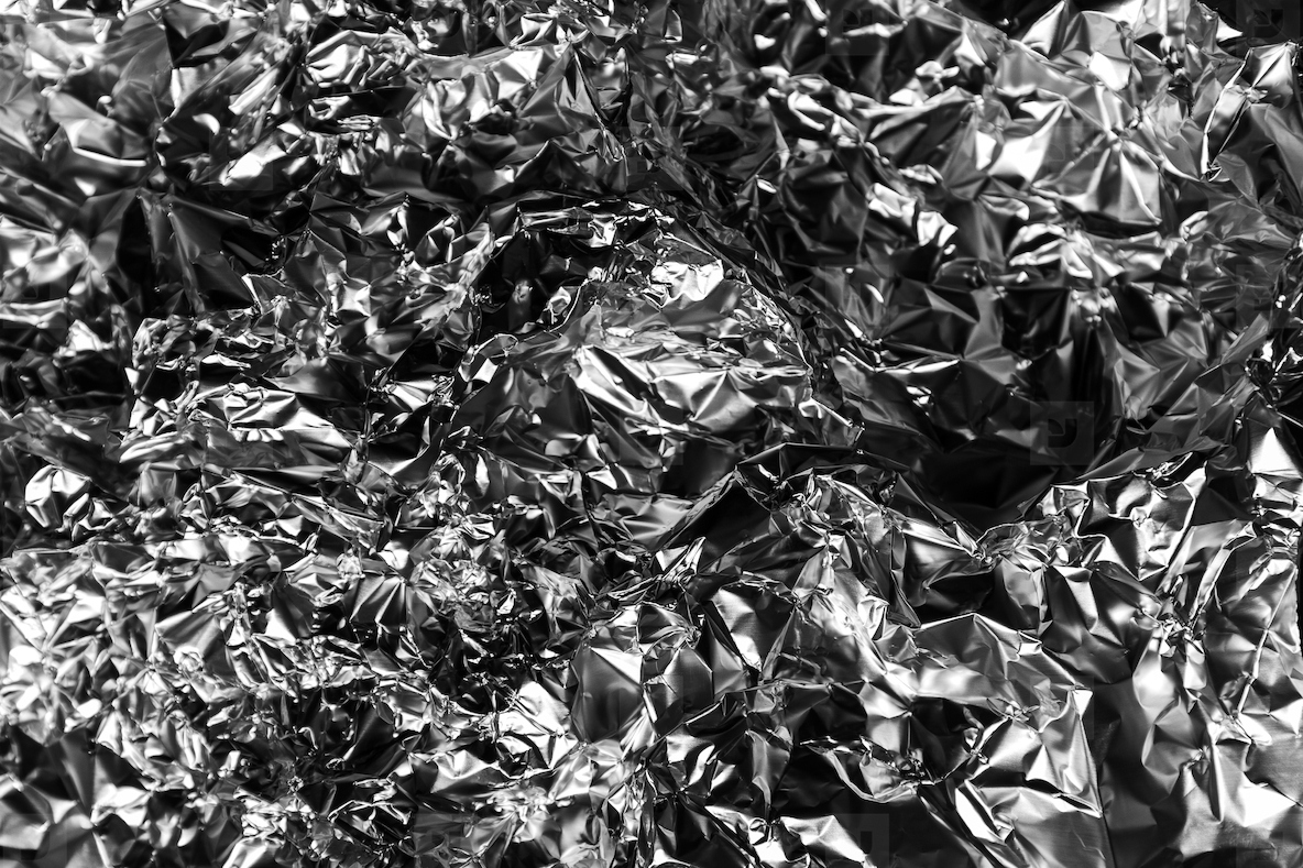 Shiny crumpled foil with metallic abstract look futuristic texture chrome surface and cyberpunk style reflective pattern