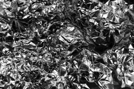 Shiny crumpled foil with metallic abstract look  futuristic texture  chrome surface and cyberpunk style reflective pattern