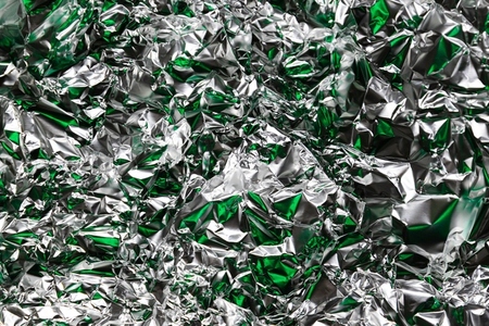 Crumpled foil with silver and green reflections  metallic abstract style  futuristic texture  chrome surface and cyberpunk pattern