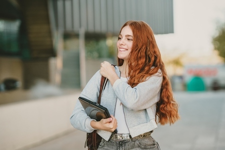 A Young Woman with Vibrant Red Hair is Joyfully Smiling in a Bustling Urban Setting A Young Woman with Vibrant Red Hair is Joyfully Smiling in a Bustling Urban Setting