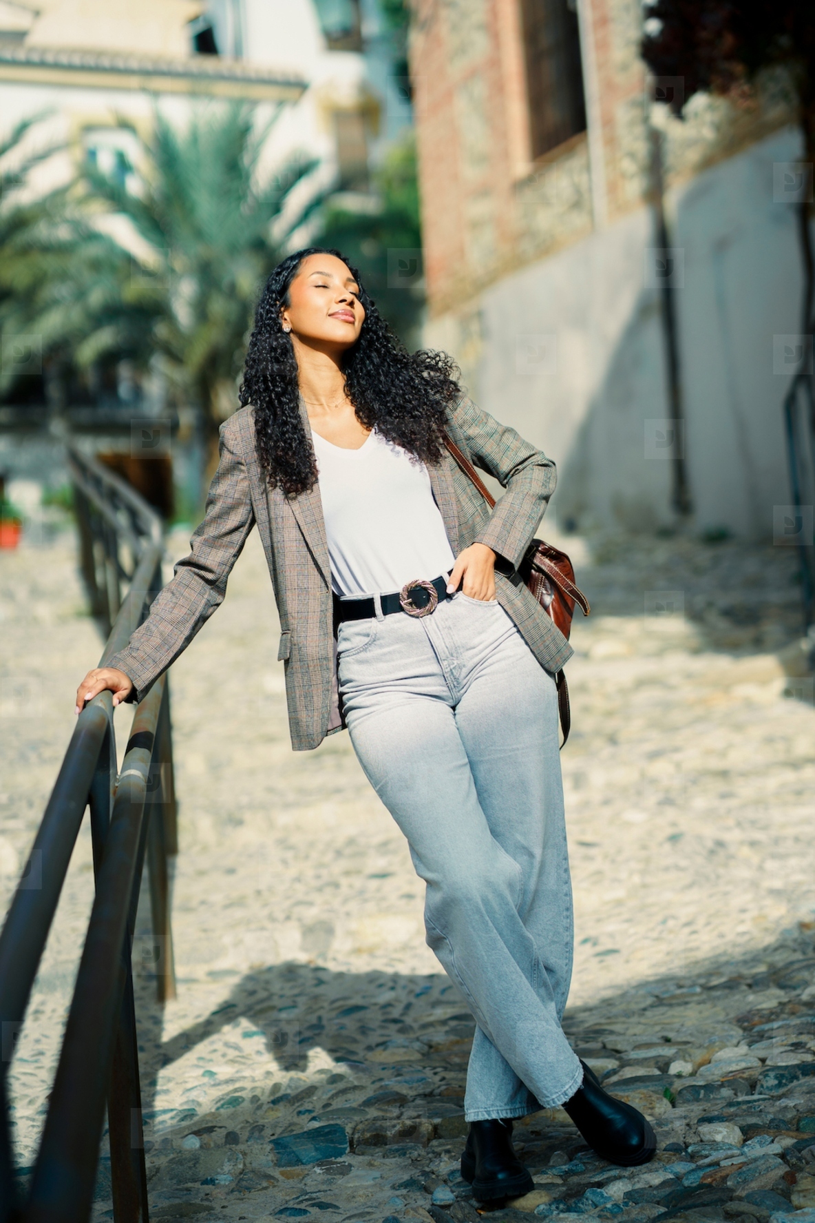 A Fashionable Young Woman is Posing Outdoors in Her Stylish Attire and Accessories