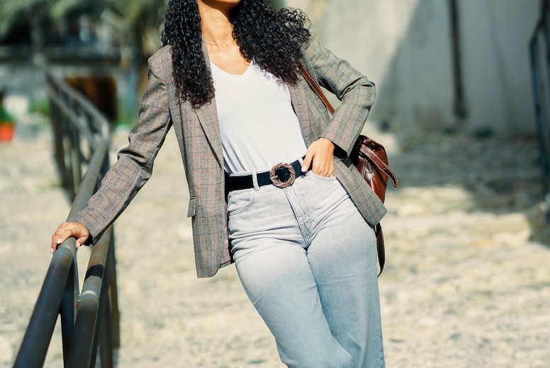 A Fashionable Young Woman is Posing Outdoors in Her Stylish Attire and Accessories