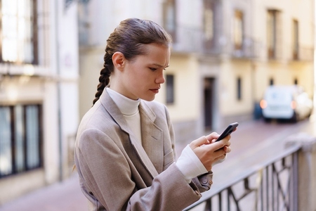 Young woman using her smartphone in a lively urban setting merging tech with daily life Young woman using her smartphone in a lively urban setting merging tech with daily life