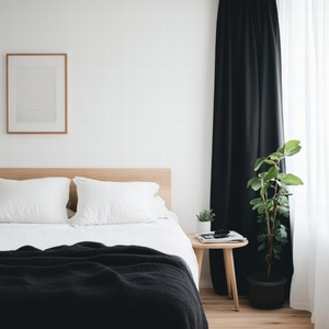 Scandinavian minimalism bedroom with white bedding  black blanket  wooden furniture  green plant