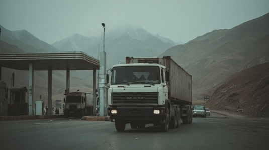 Cargo truck border customs checkpoint mountain road overcast transport