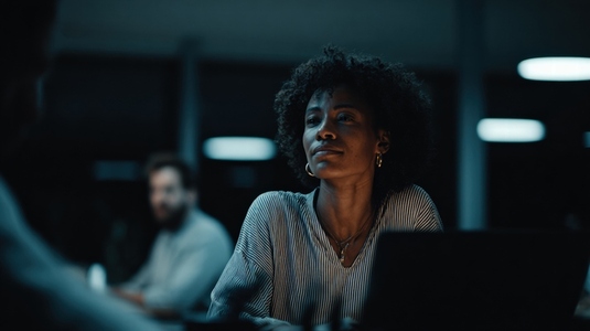 Woman office night thoughtful computer professional business technology focused modern workspace