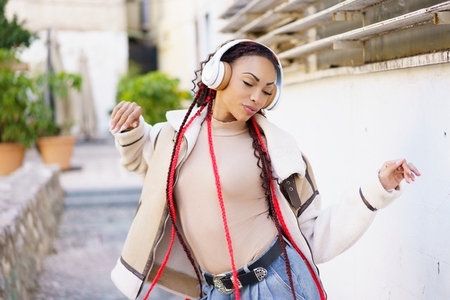 A Young Woman has a wonderful experience Enjoying Music Outdoors while wearing Headphones