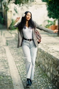 Stylish and fashionable woman in a vibrant urban setting  confidently wearing headphones