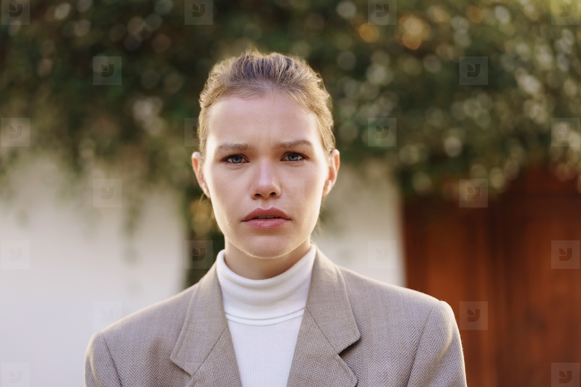 A Confident Young Woman Poses in a Stylish Blazer Against a Soft  Natural Background