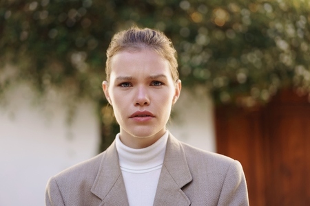 A Confident Young Woman Poses in a Stylish Blazer Against a Soft  Natural Background