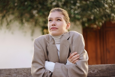 Contemplative Young Woman Dressed in a Cozy Sweater and an Oversized Fashion Blazer Contemplative Young Woman Dressed in a Cozy Sweater and an Oversized Fashion Blazer