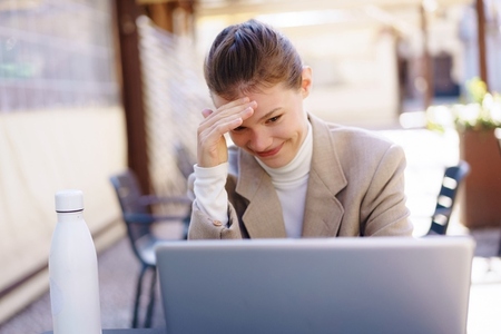 A stressedout professional is working diligently on a laptop while outdoors in nature