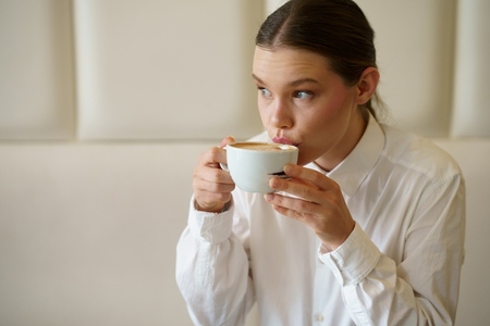 Elegant beauty businesswoman sipping a latte in a chic cafeteria Elegant beauty businesswoman sipping a latte in a chic cafeteria