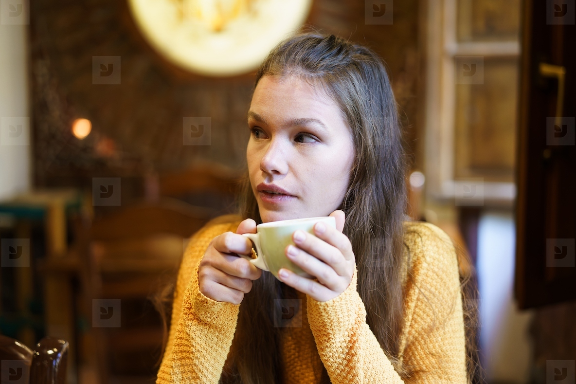 Contemplative Woman Enjoying Coffee in Cozy Caf Setting