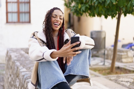 A Happy and Young Woman Enjoying a Video Call While in a Beautiful Outdoor Setting A Happy and Young Woman Enjoying a Video Call While in a Beautiful Outdoor Setting