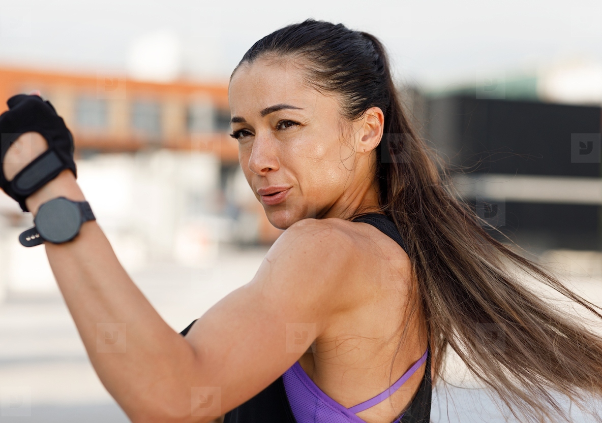 Woman doing high intense warming up  High detailed portrait of a muscular athlete practicing punches outdoors