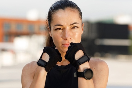 Close up portrait of a young female in a fighting stance  ready for shadow boxing outdoors