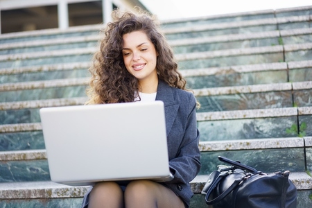 A young professional works on a laptop outdoors  enjoying fresh air and a modern lifestyle