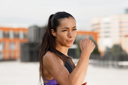 Young female athlete practicing punches outdoors  standing on the roof