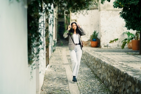 A Stylish Woman Gracefully Walking Through a Charming and Scenic Alleyway in the City A Stylish Woman Gracefully Walking Through a Charming and Scenic Alleyway in the City
