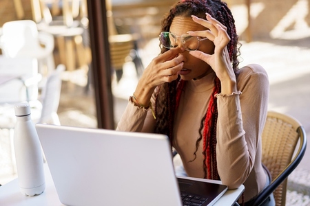 Stressed Young Woman Working on Laptop in Caf Environment