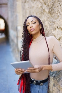 A Confident Woman Holding a Tablet in a Vibrant Urban Setting on a Beautiful Day A Confident Woman Holding a Tablet in a Vibrant Urban Setting on a Beautiful Day
