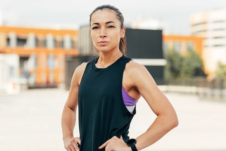 Portrait of a confident woman with her hands on her hips  looking at camera while standing on the roof