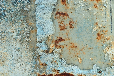 Close up of cracked peeling paint and rust on an old metal surface  creating a grunge abstract texture with weathered details