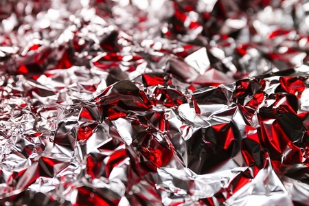Shiny crumpled foil with silver and red reflections creating a metallic abstract design  Futuristic texture with chrome surface and cyberpunk background style