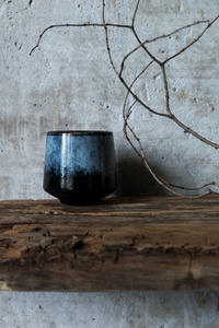 Dark ceramic cup on rustic wood with dry branch against concrete wall  minimal wabi sabi still life with natural textures