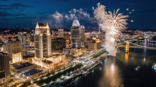 Aerial cityscape night view with fireworks  river  illuminated buildings  festive atmosphere
