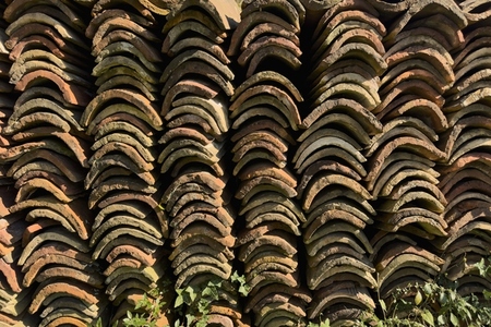 Curved roof tiles stacked in rows in sunlight Curved roof tiles stacked in rows in sunlight