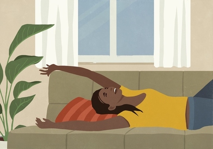 Happy carefree young woman relaxing laying on living room sofa