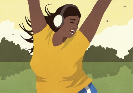 Carefree young woman listening to music with headphones and dancing