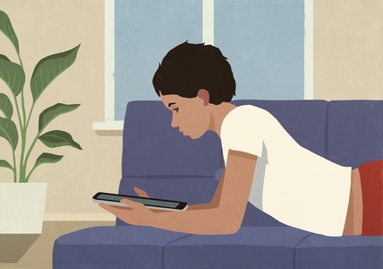 Boy relaxing at home laying on living room sofa Boy relaxing at home laying on living room sofa