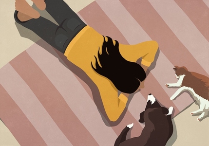 View from above woman relaxing on rug with pet dog and cat