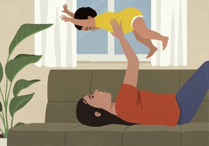 Happy mother holding baby son overhead on living room sofa
