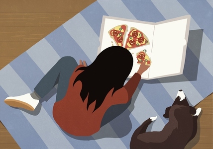 High angle view of girl eating pizza on floor next to pet dog