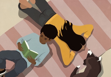 View from above boy reading book on floor by mom and pet dog