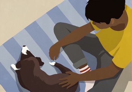 High angle view boy petting dog on rug