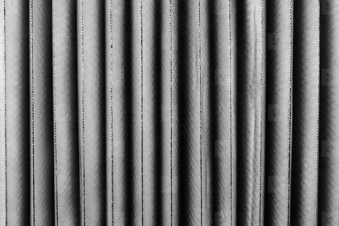 Vertical fabric folds with smooth textile texture soft light and elegant minimal pattern in monochrome design