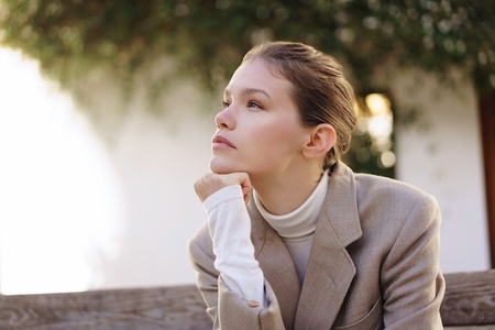 A Thoughtful Young Woman Dressed in Stylish Attire Deep in Contemplation While Outdoors A Thoughtful Young Woman Dressed in Stylish Attire Deep in Contemplation While Outdoors