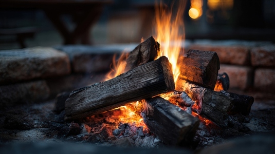 Cozy campfire burning with wooden logs  creating warm and inviting atmosphere for relaxation and gathering