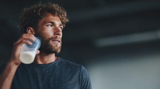 Athlete enjoying protein shake after workout  showcasing determination and focus in fitness environment
