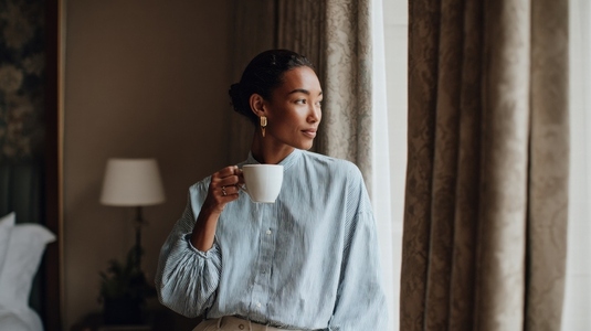 Elegant woman sipping coffee in boutique hotel  showcasing serene moment of reflection and style