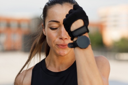Close up high detailed portrait of young female in gloves doing shadow punches outdoors with closed eyes